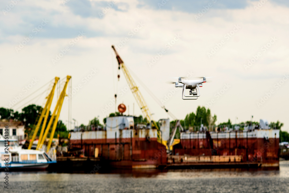 Drone with camera flying on container cargo ship at shipping port. double exposure