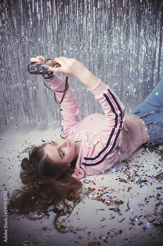 happy  beautiful  young blonde  with vintage camera  on the background of garland and tinsel