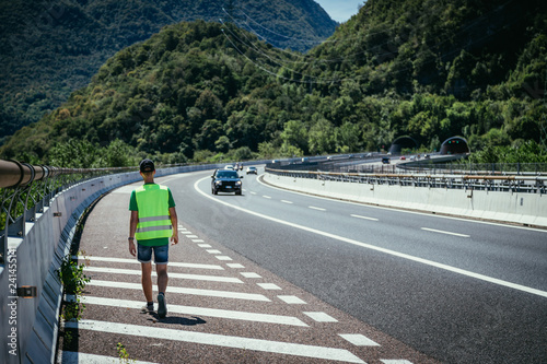 Man in reflective vest arranges a warning triangle  car breakdown on the highway