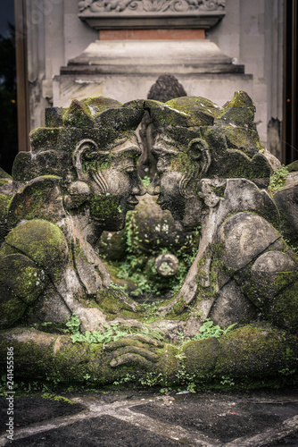 Traditional balinese stone sculpture of a man and woman photo