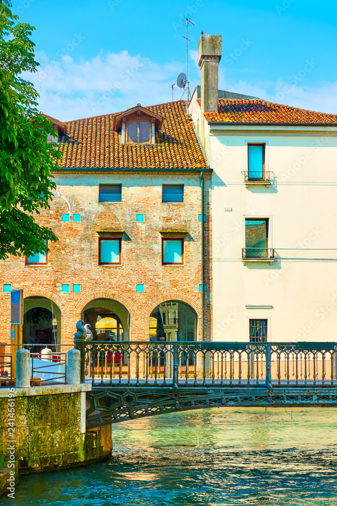 Old buildings and small canal with bridge in Treviso