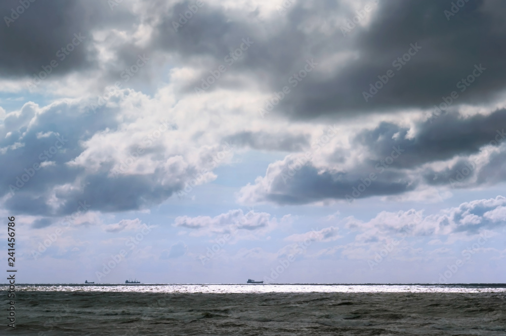 The sea before the storm. Clouds over the sea. Ships on the horizon.