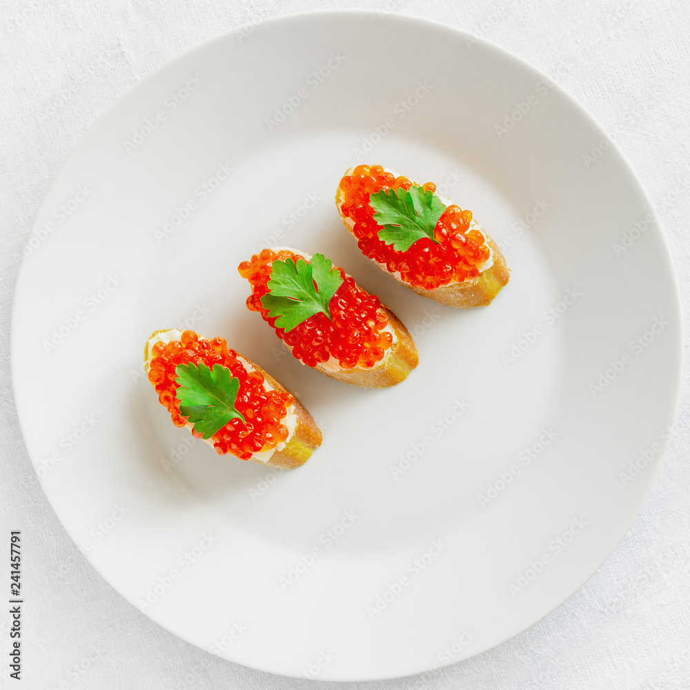 baguette slices with butter and red caviar decorated with parsley baguette slices with butter and red caviar decorated with parsley