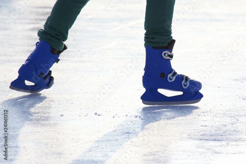 legs in blue skating on the ice rink