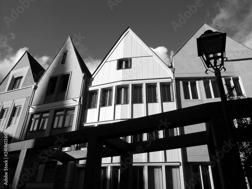 Neu erbaute Häuserzeile mit alter Straßenlaterne bei Sonnenschein in der neuen Altstadt am Römerberg in Frankfurt am Main in Hessen, fotografiert in klassischem Schwarzweiß photo