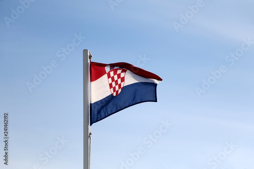 Flag of Croatia, blowing in the wind. Clear blue sky in the background.