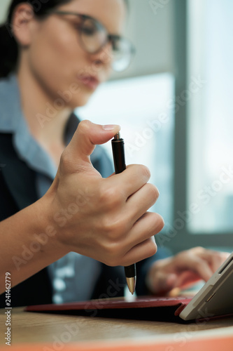 Bored Businesswoman Cliking Pen Repeatedly While Working at Office