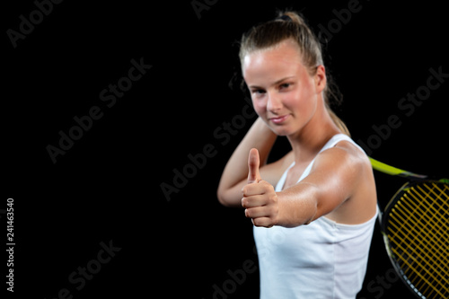 Female athlete posing with tennis racket against black background © FS-Stock