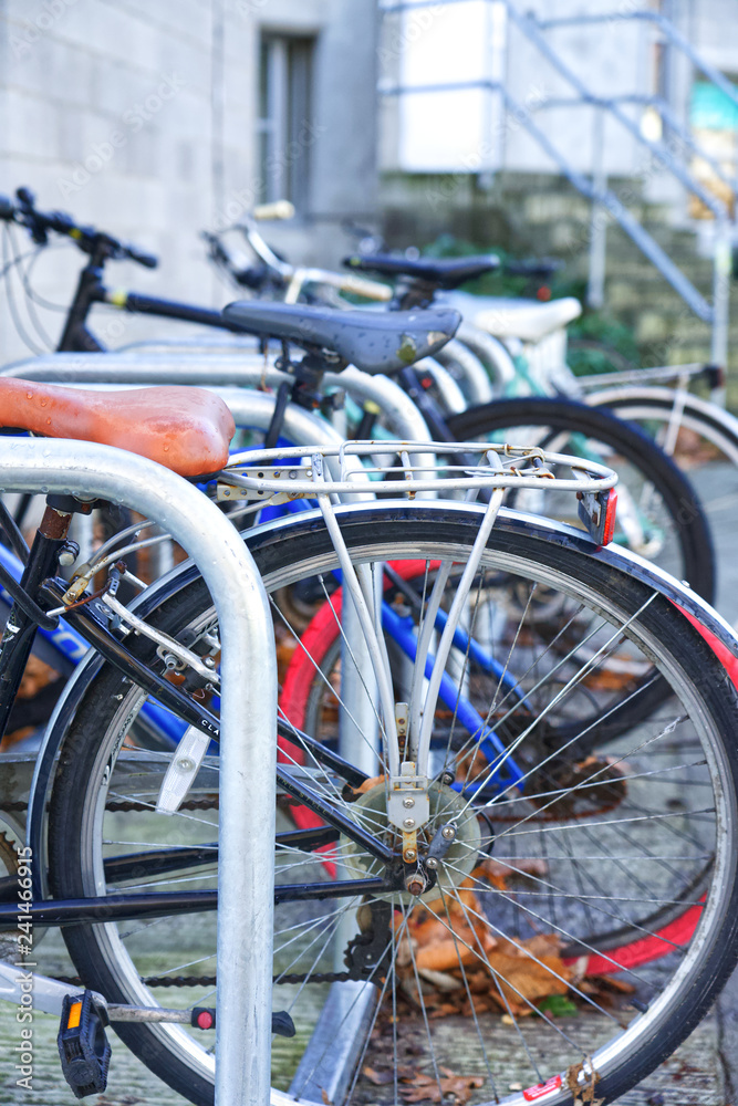 seveeral bicycles secured to metal bike racks in an urban environment 
