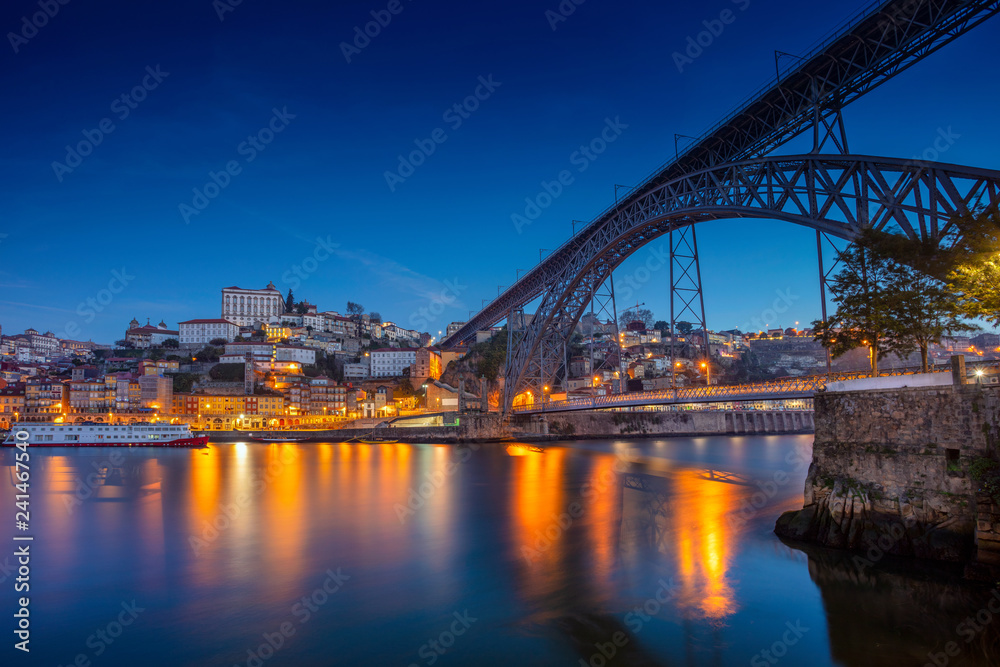 Porto, Portugal. Cityscape image of Porto, Portugal with reflection of the city in the Douro River and the Luis I Bridge during twilight blue hour.
