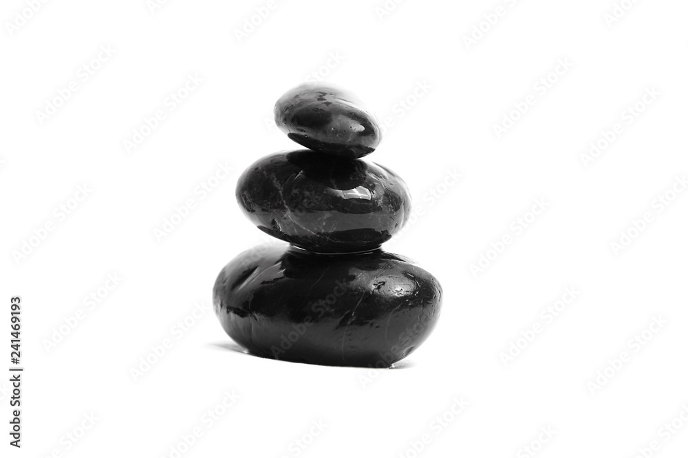 Stacked smooth black stones. Sea pebble. Balancing wet pebbles isolated on white background