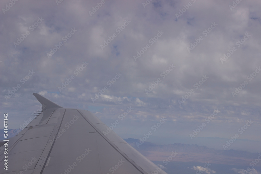 wing of an airplane flying above the clouds