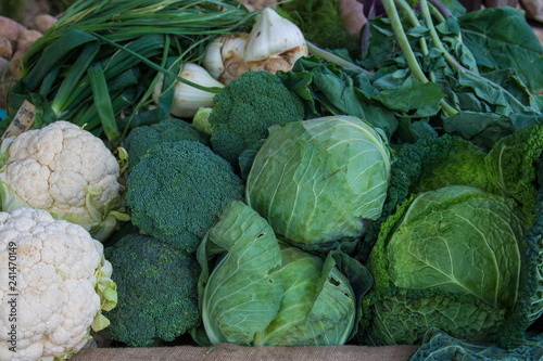 Various vegetables on market stall: cauliflower, broccoli,  cabbage, green onions.
