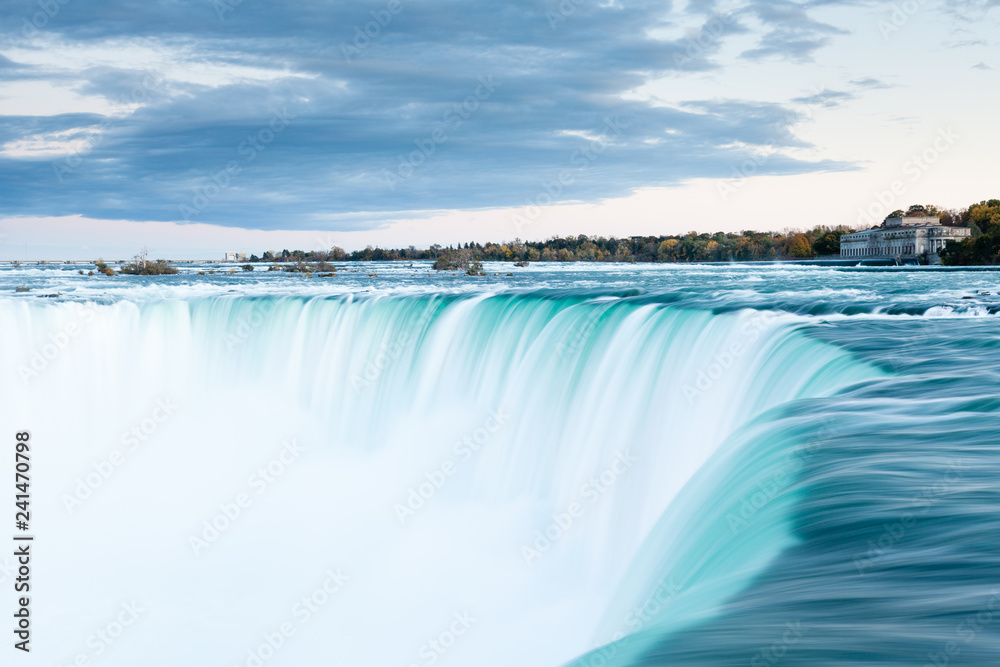 The view across the Horseshoe Falls at dusk, a part of the Niagara Falls, viewed from the Canadian side. The falls straddle the border between America and Canada. The view across the Horseshoe Falls at dusk, a part of the Niagara Falls, viewed from the Canadian side. The falls straddle the border between America and Canada.