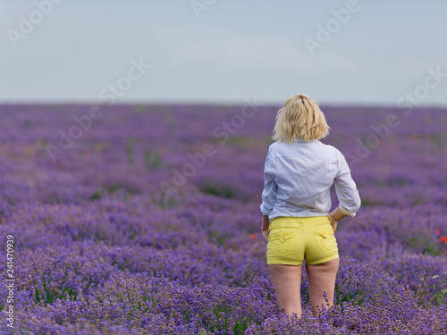 Fototapeta Naklejka Na Ścianę i Meble -  Young girl posing in a lavender field. Back view.