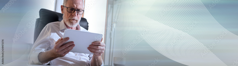 Senior businessman using a digital tablet, hard light. panoramic banner Senior businessman using a digital tablet, hard light. panoramic banner