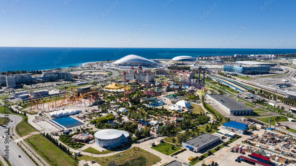 RUSSIA, SOCHI - JUL 27, 2018: Amusement park near hotel Bogatyr at summer sunny day. Aerial view. Photo with noise from action camera