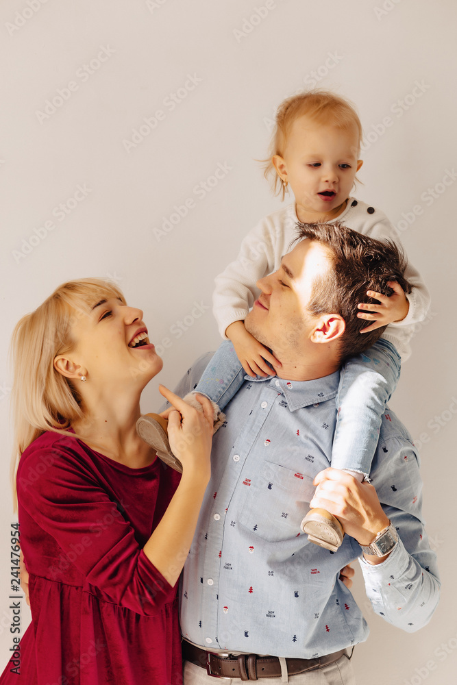 beautiful family with a small daughter, a simple background, happiness and joy beautiful family with a small daughter, a simple background, happiness and joy