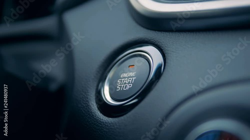 A driver starts and stops engine in a car, close up.