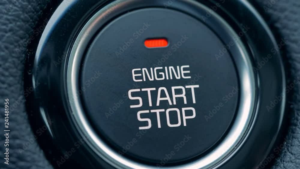 A driver starts a car, pressing a button, close up. A driver starts a car, pressing a button, close up.