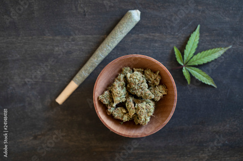 Wooden bowl of marijuana and a rolled joint