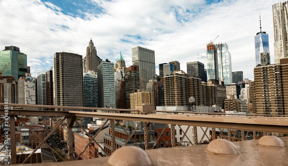 Naklejka premium Manhattan skyline seen from the beautiful Brooklyn bridge. Cloudy day in New York City, USA.