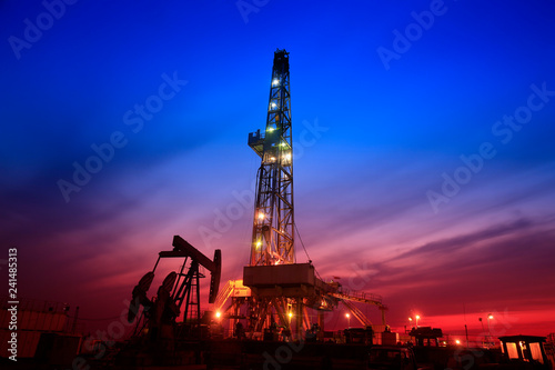 The pumping unit is at work in the evening of the oilfield