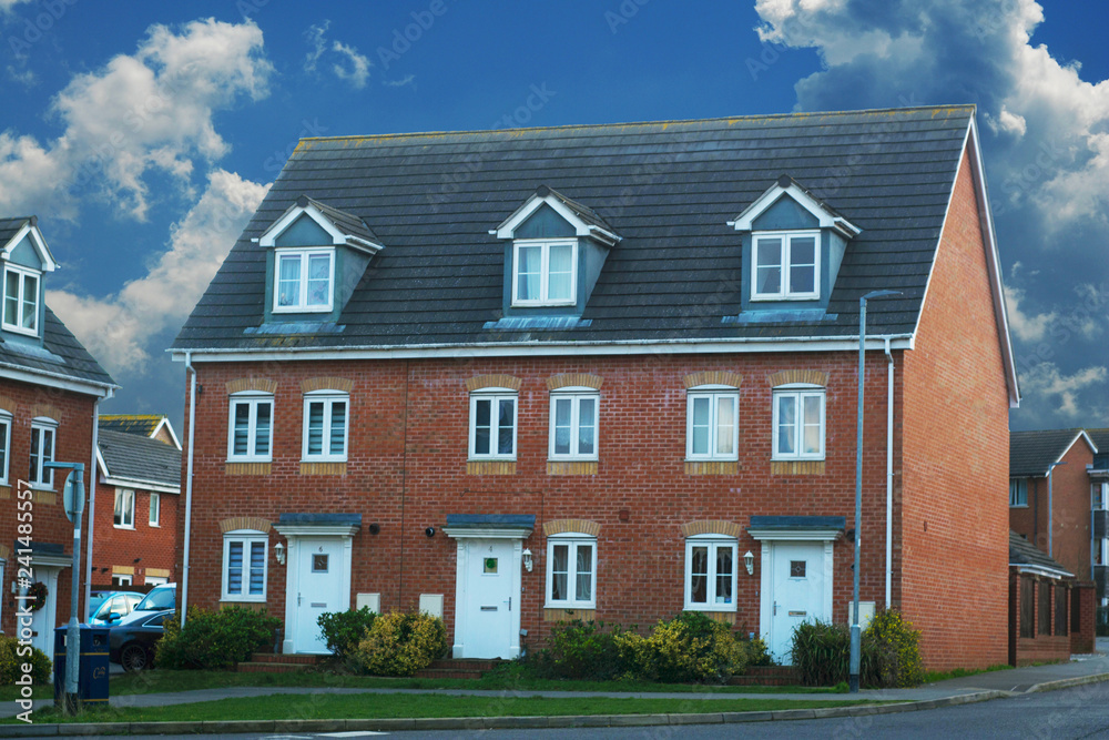 Corby, United Kingdom - 01 January 2019. Traditional english house, brick house. Outdoor, street view. Blue sky.