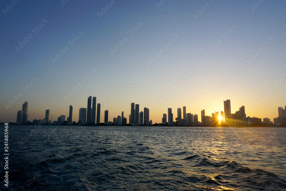 Cartagena / Colombia - 12 25 2018: Panoramic view of the coastline of the city and the sea with blue sky with some boats or ships with a sunset and buildings