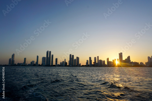 Cartagena / Colombia - 12 25 2018: Panoramic view of the coastline of the city and the sea with blue sky with some boats or ships with a sunset and buildings © juancamilo