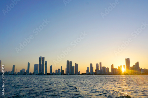 Cartagena / Colombia - 12 25 2018: Panoramic view of the coastline of the city and the sea with blue sky with some boats or ships with a sunset and buildings © juancamilo