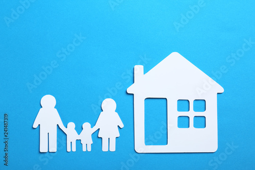 Paper silhouettes of family and house on color background, flat lay. Life insurance concept