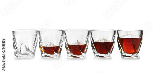 Empty and full whiskey glasses on white background