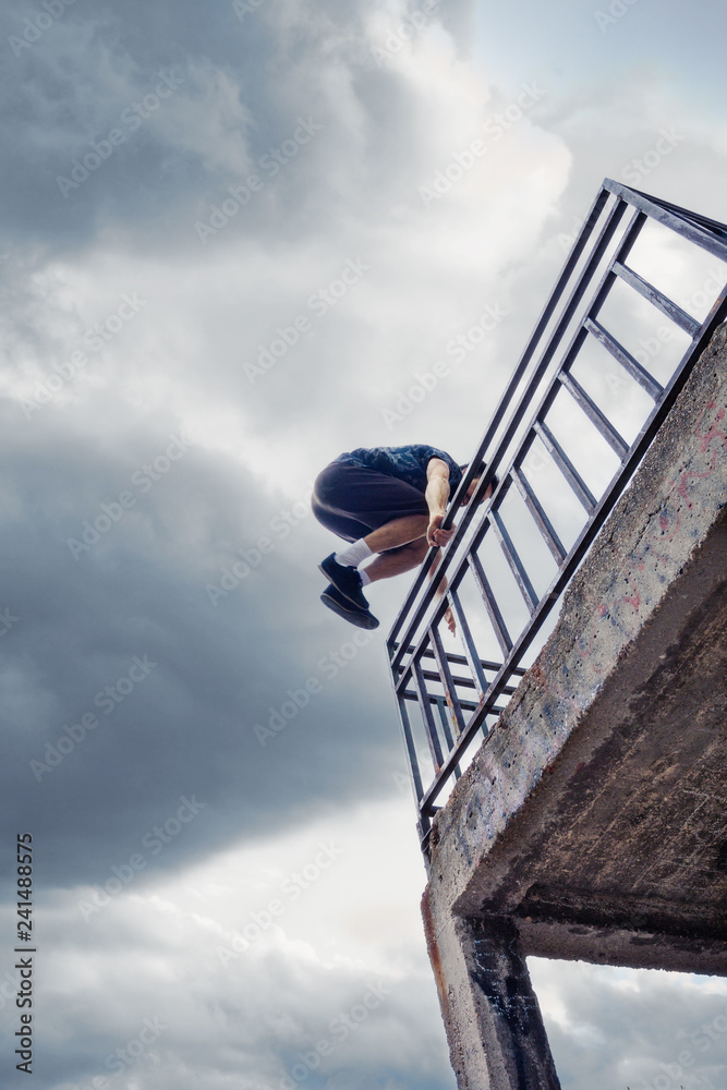 young man practice parkour in  ithe city  summer day