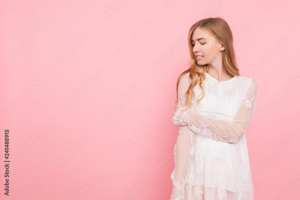 Beautiful thoughtful girl in a white dress, dreams of something, making plans, on a pink background Beautiful thoughtful girl in a white dress, dreams of something, making plans, on a pink background