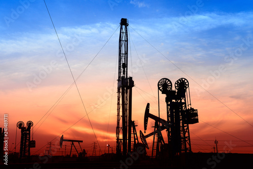 Foto The pumping unit is at work in the evening of the oilfield