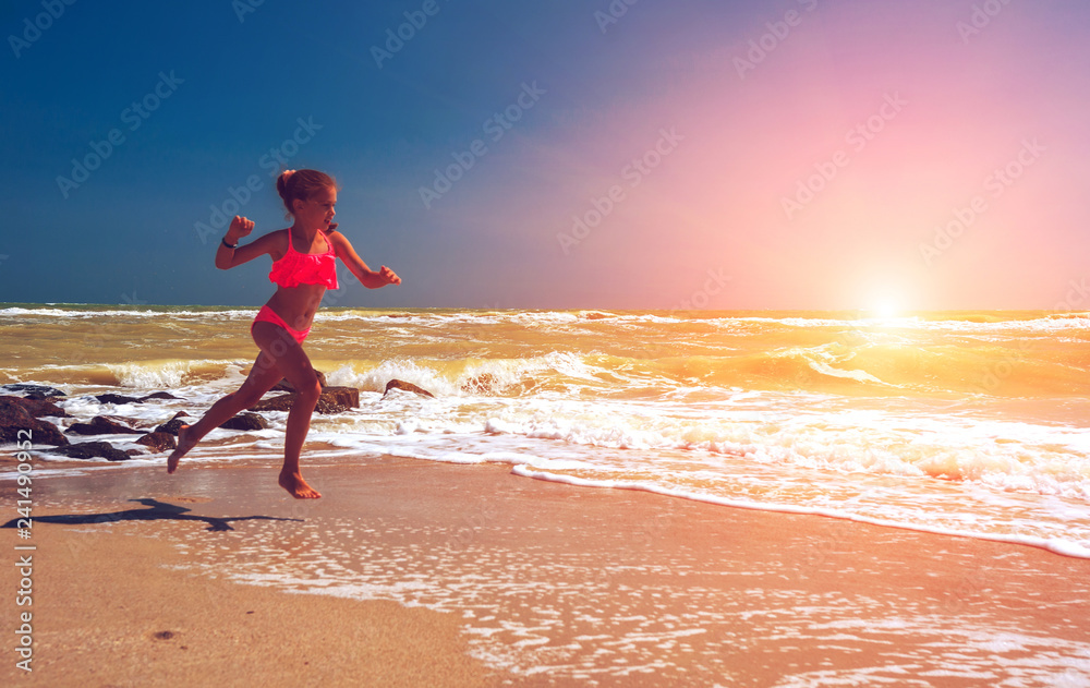 llovely girl, runs along the ocean at sunset. beautiful teen girl.