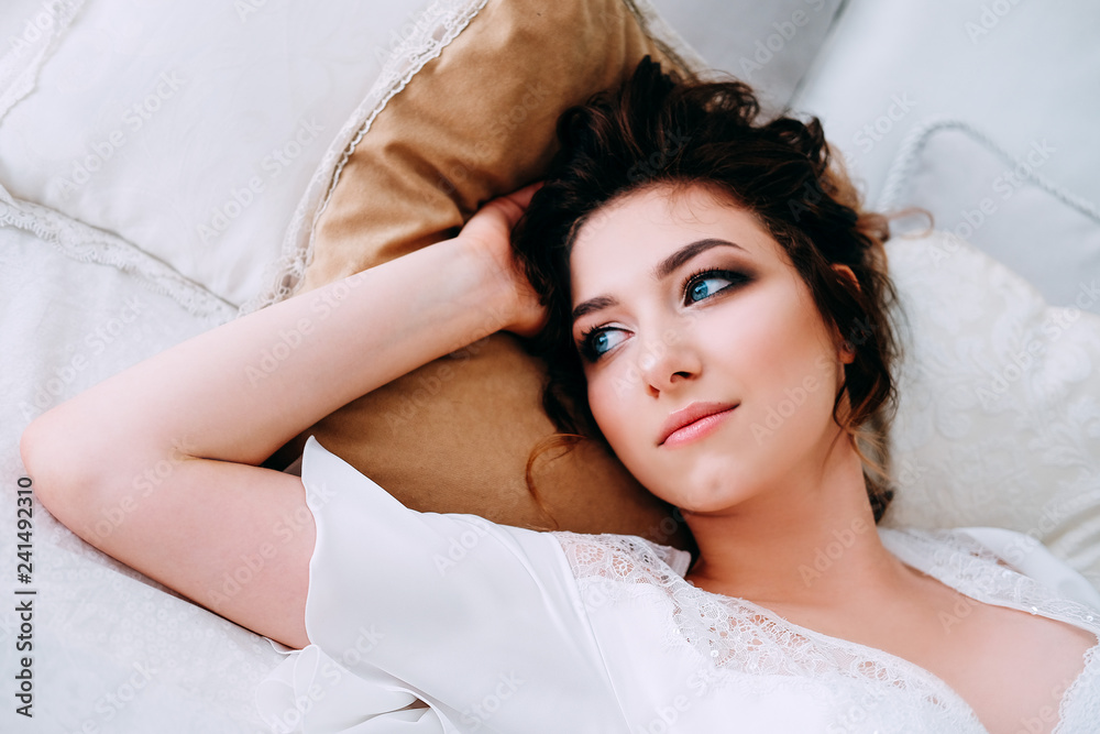 Beautiful brunette in silk robe sleeping on the bed Beautiful brunette in silk robe sleeping on the bed