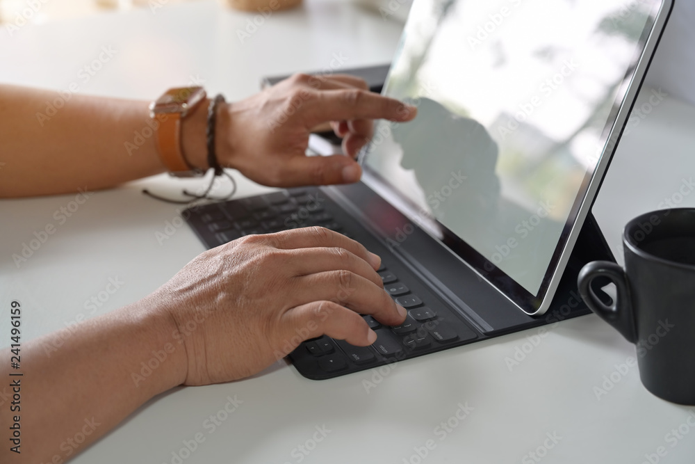 Man working with tablet on desk. Man working with tablet on desk.