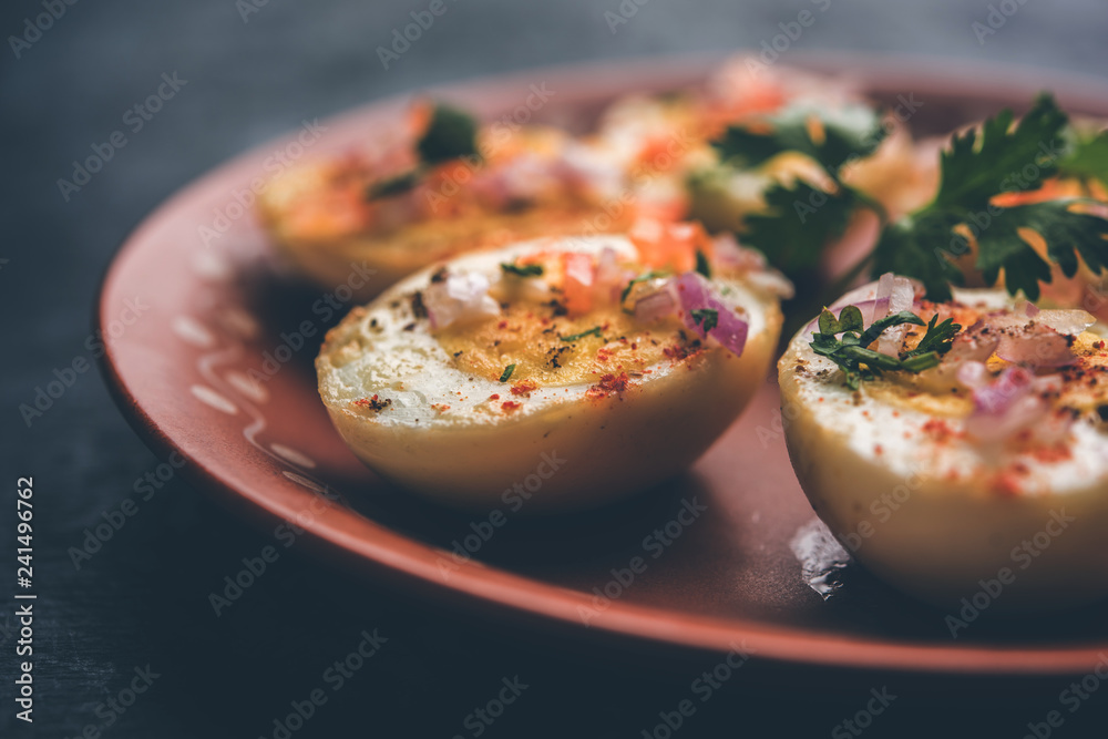 Fried hot boiled egg masala is a popular healthy breakfast or starter menu from India. With onion, coriander, black pepper, tomato and salt sprinkled over half of eggs Fried hot boiled egg masala is a popular healthy breakfast or starter menu from India. With onion, coriander, black pepper, tomato and salt sprinkled over half of eggs