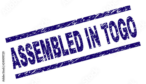 ASSEMBLED IN TOGO seal stamp with distress style. Blue vector rubber print of ASSEMBLED IN TOGO text with grunge texture. Text caption is placed between parallel lines.