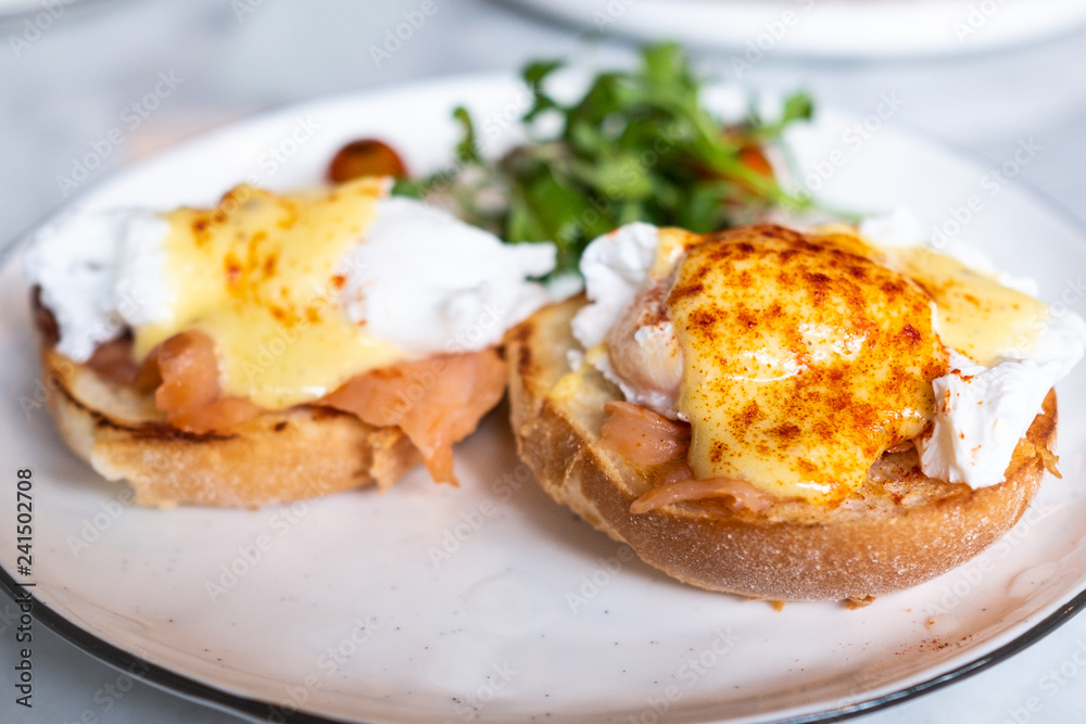 Eggs Benedict, English muffin topped with a poached egg, smoked salmon, and hollandaise sauce. Eggs Benedict, English muffin topped with a poached egg, smoked salmon, and hollandaise sauce.