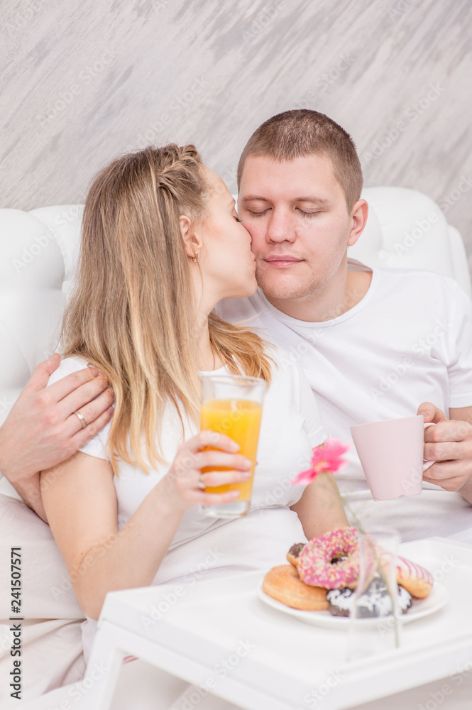 Happy young family. Romantic couple having breakfast in bed
