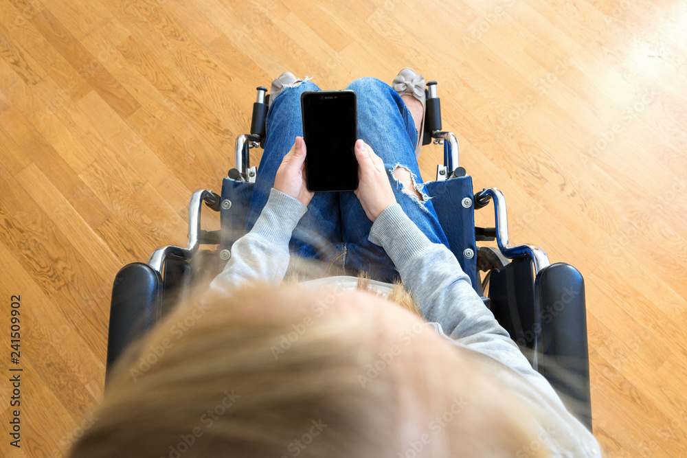 Disabled woman in wheelchair using smartphone. Top view, mock up. Stock  Photo | Adobe Stock