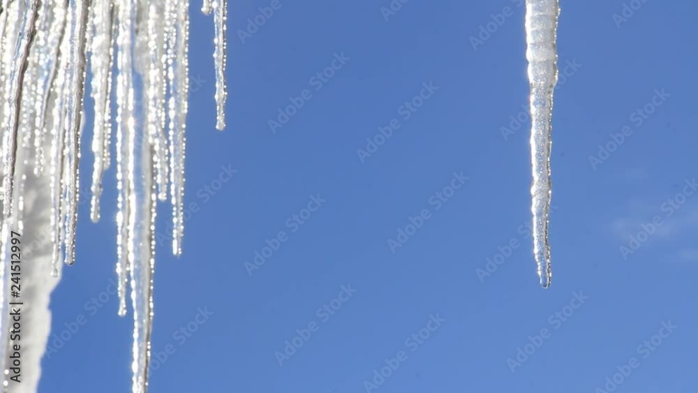 氷柱から滴り落ちる水滴　冬　青空