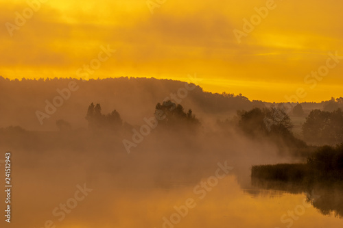 fairytale misty morning by the lake. Golden fog surrounding the lake