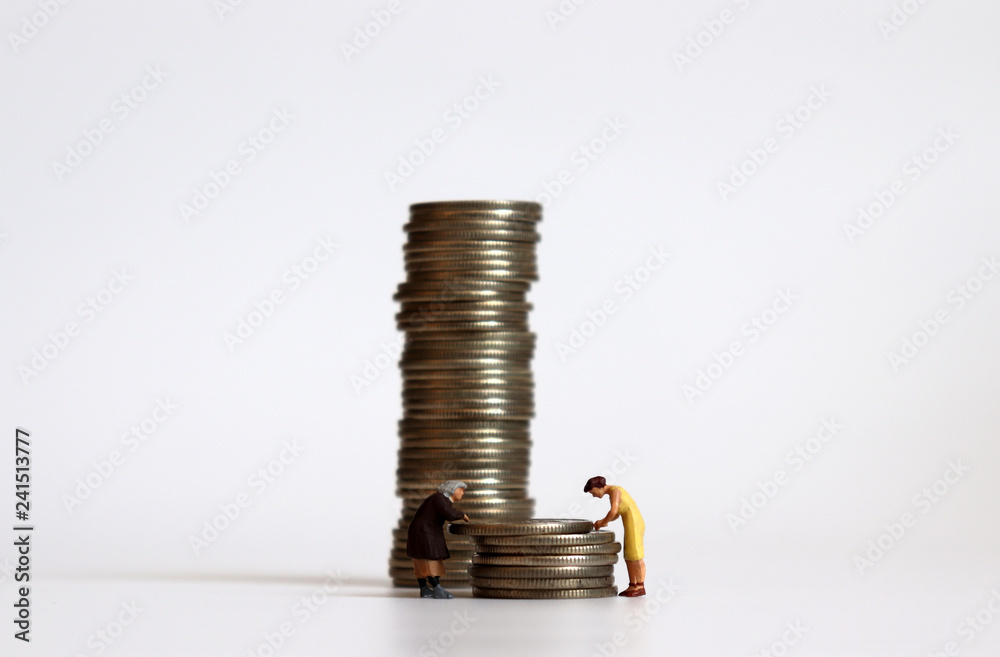 Miniature people with a pile of coins. The concept of women's economic inequality. Miniature people with a pile of coins. The concept of women's economic inequality.