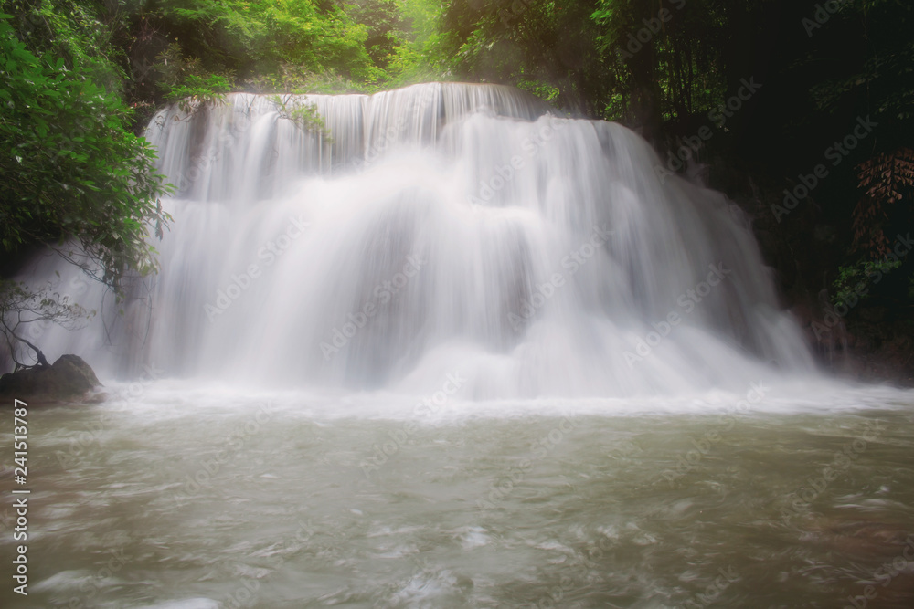 Waterfall in forest at sunrise.