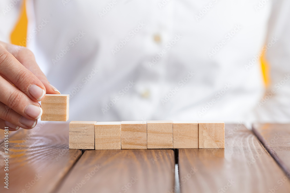 Woman hand arranging wooden cubes Woman hand arranging wooden cubes