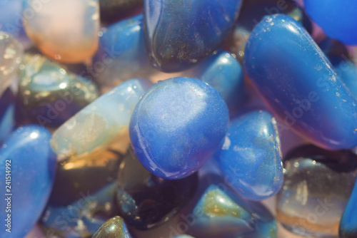 Blue raw transparent agate stones shining at the sun close up texture background